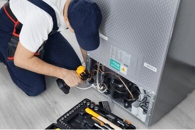 male technician repairs refrigerator kitchen 260nw 2427322851 e1745847294857